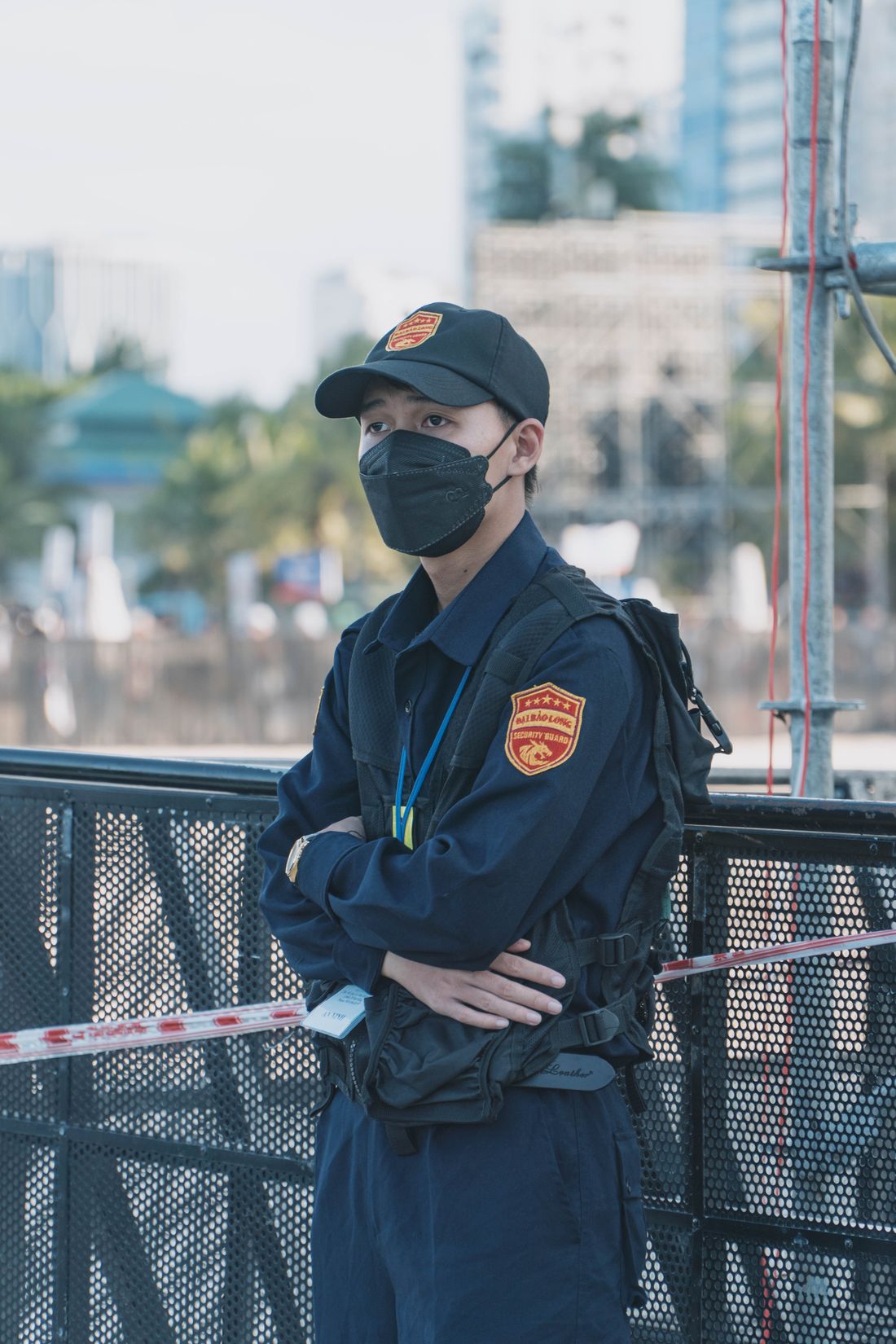 Sicherheitsmitarbeiter in dunkler Uniform mit verschränkten Armen